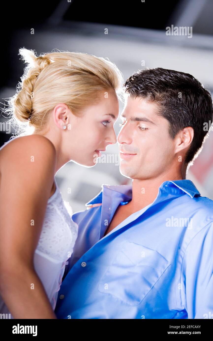 Close-up of a young woman and a mid adult man embracing each other ...