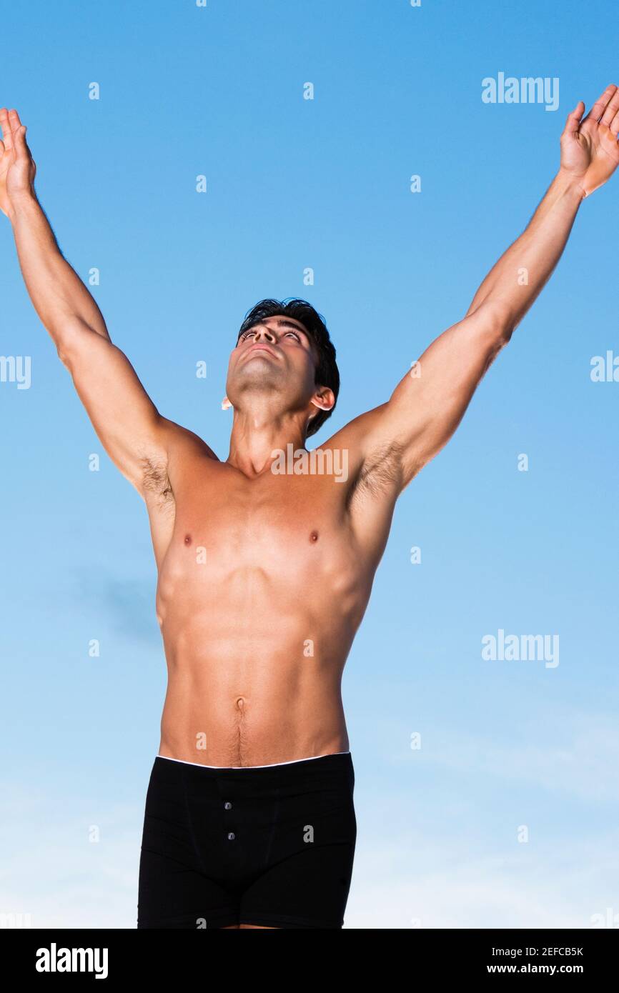 Close-up of a young man standing with his arms raised Stock Photo