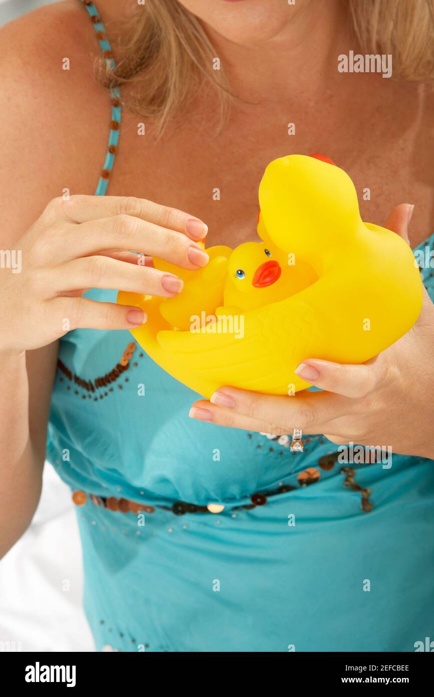 Close-up of a mid adult woman holding rubber ducks Stock Photo