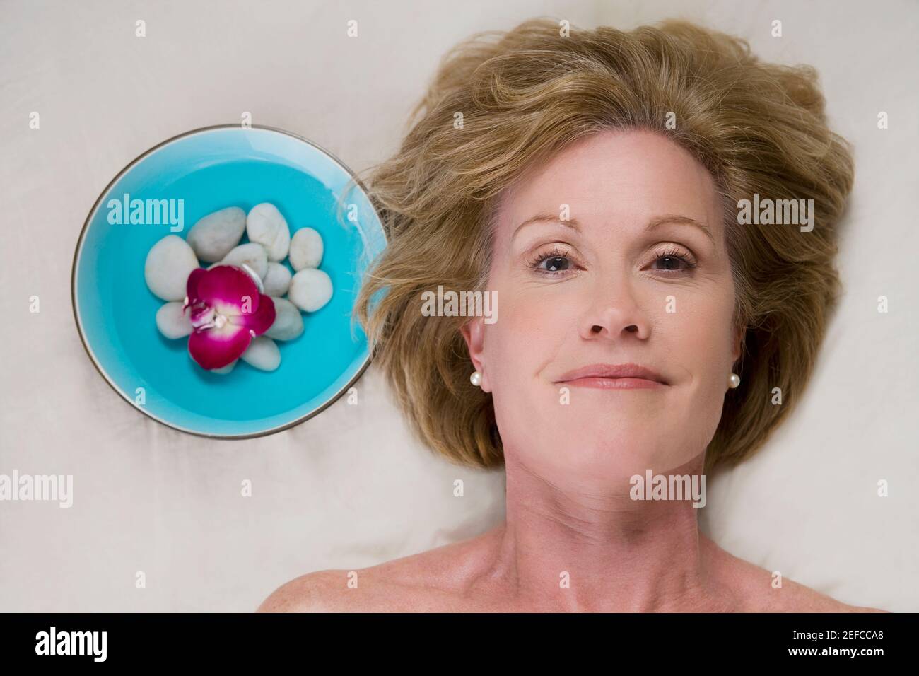 Portrait of a mature woman lying on a massage table Stock Photo - Alamy