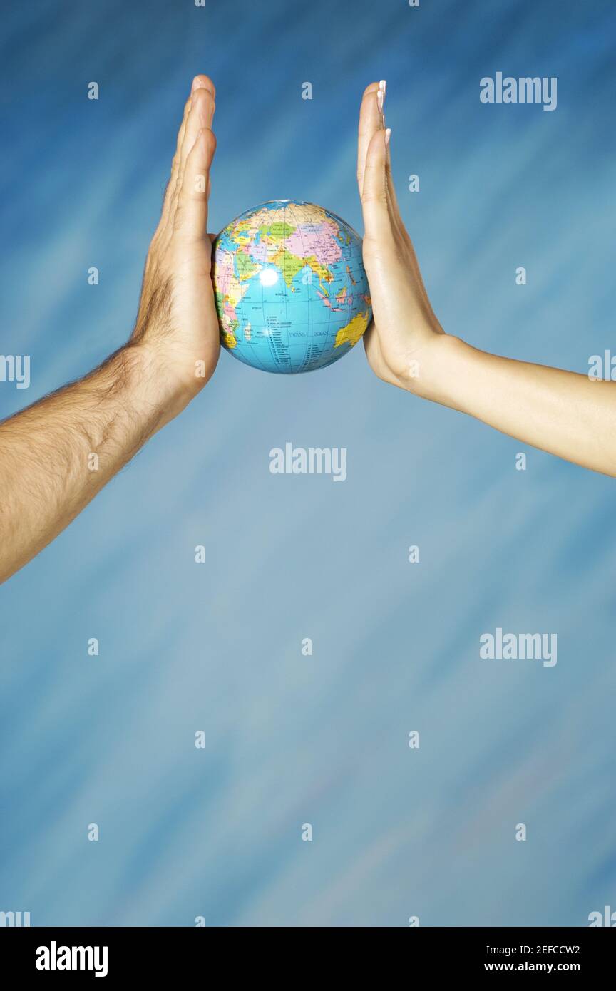 Two people holding up globe hi-res stock photography and images - Alamy