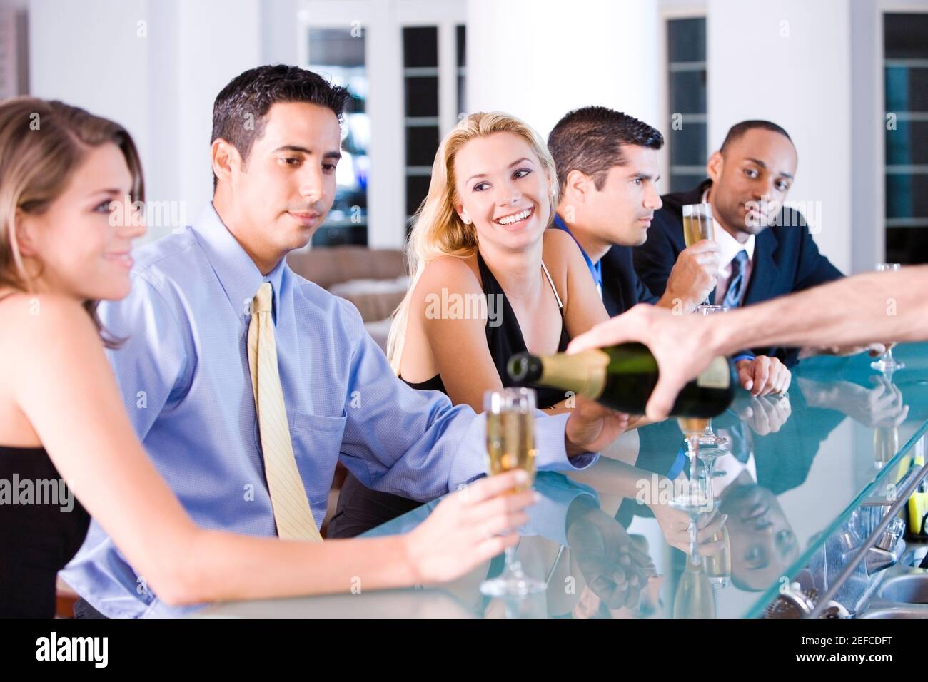 Five people sitting at a bar counter Stock Photo - Alamy