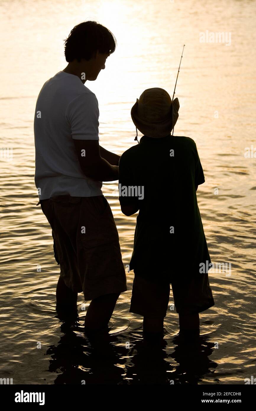Silhouette of a father and his son fishing Stock Photo - Alamy