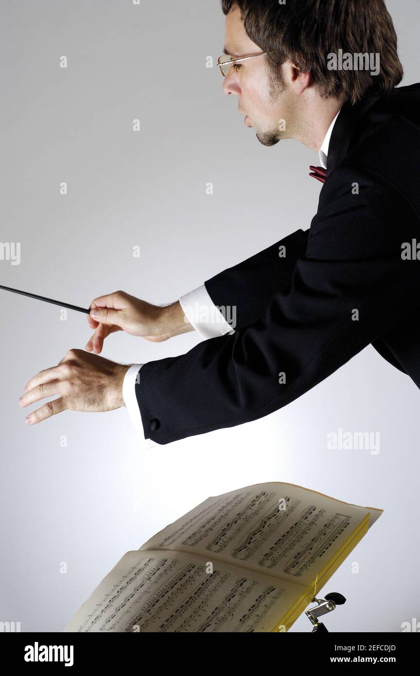 Side profile of a conductor holding a baton Stock Photo Alamy