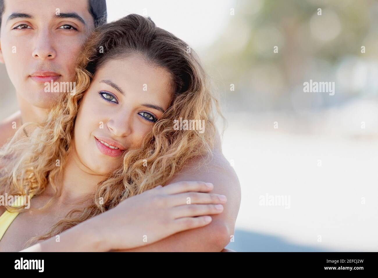 Portrait of a mid adult man embracing a young woman from behind Stock ...