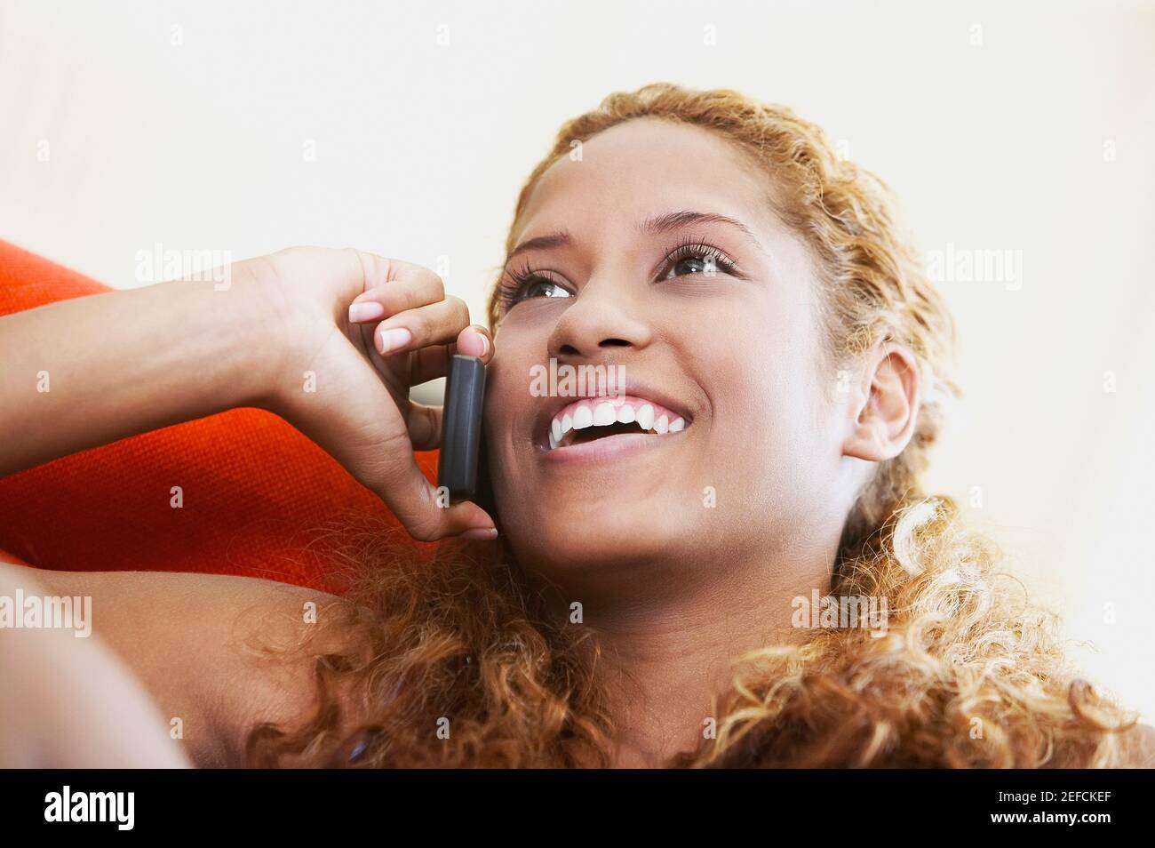 Close up of a young woman talking on a mobile phone and smiling Stock Photo