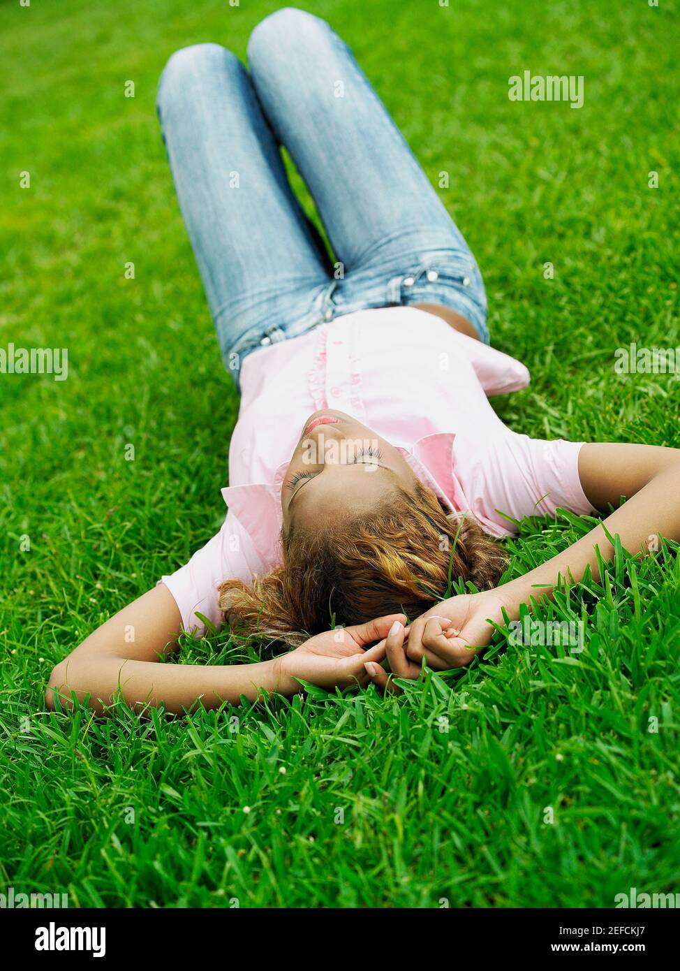 Young woman lying on the grass Stock Photo - Alamy