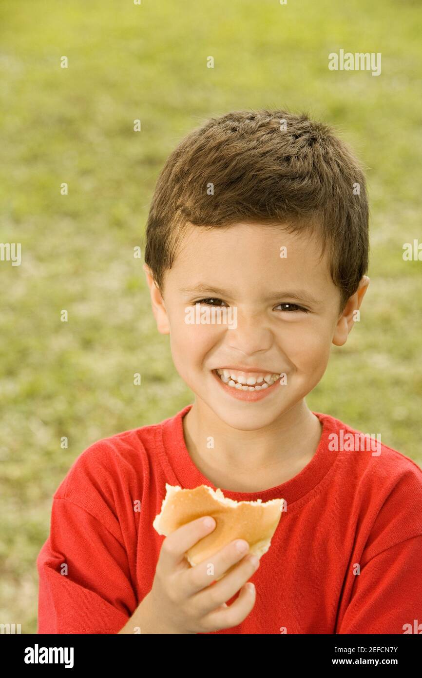 Portrait of a boy holding a burger Stock Photo