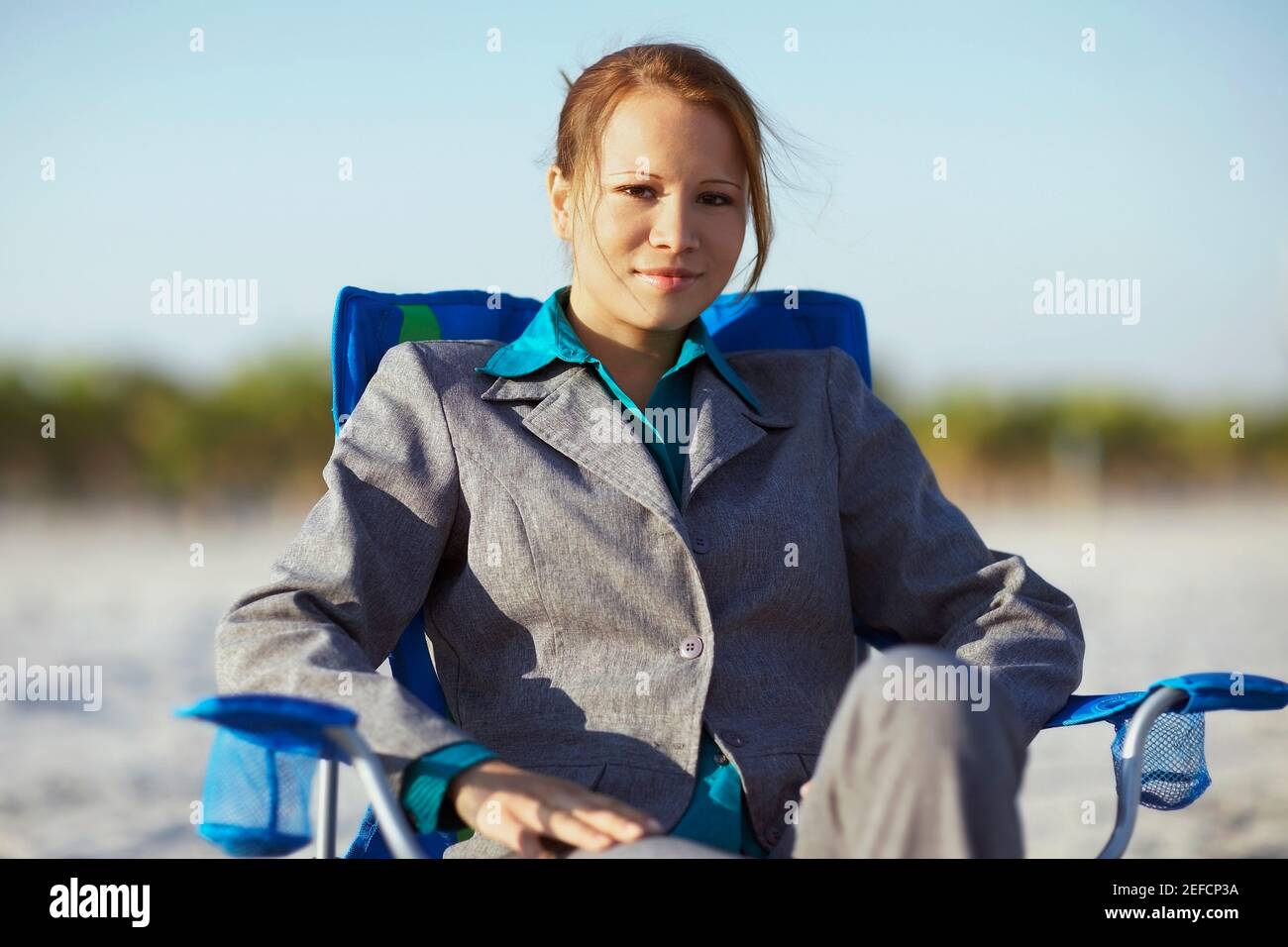 Portrait of a young woman sitting on the beach chair Stock Photo - Alamy