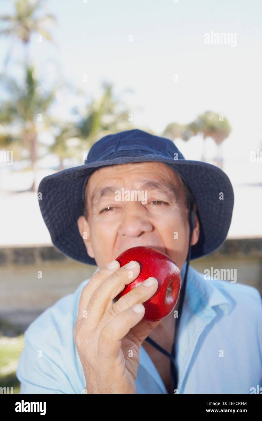 Portrait of a senior man eating an apple Stock Photo