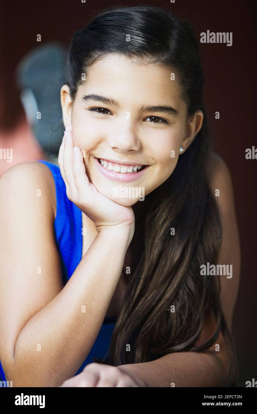 Portrait of a girl smiling with her hand on her chin Stock Photo - Alamy