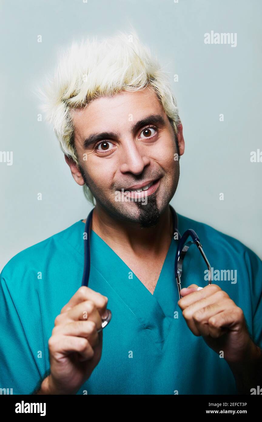 Portrait of a male doctor holding a stethoscope around his neck Stock ...