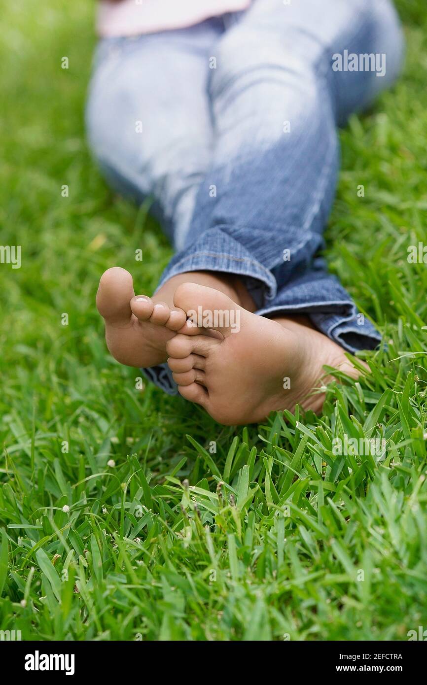 Low section view of a woman sitting on the grass Stock Photo - Alamy