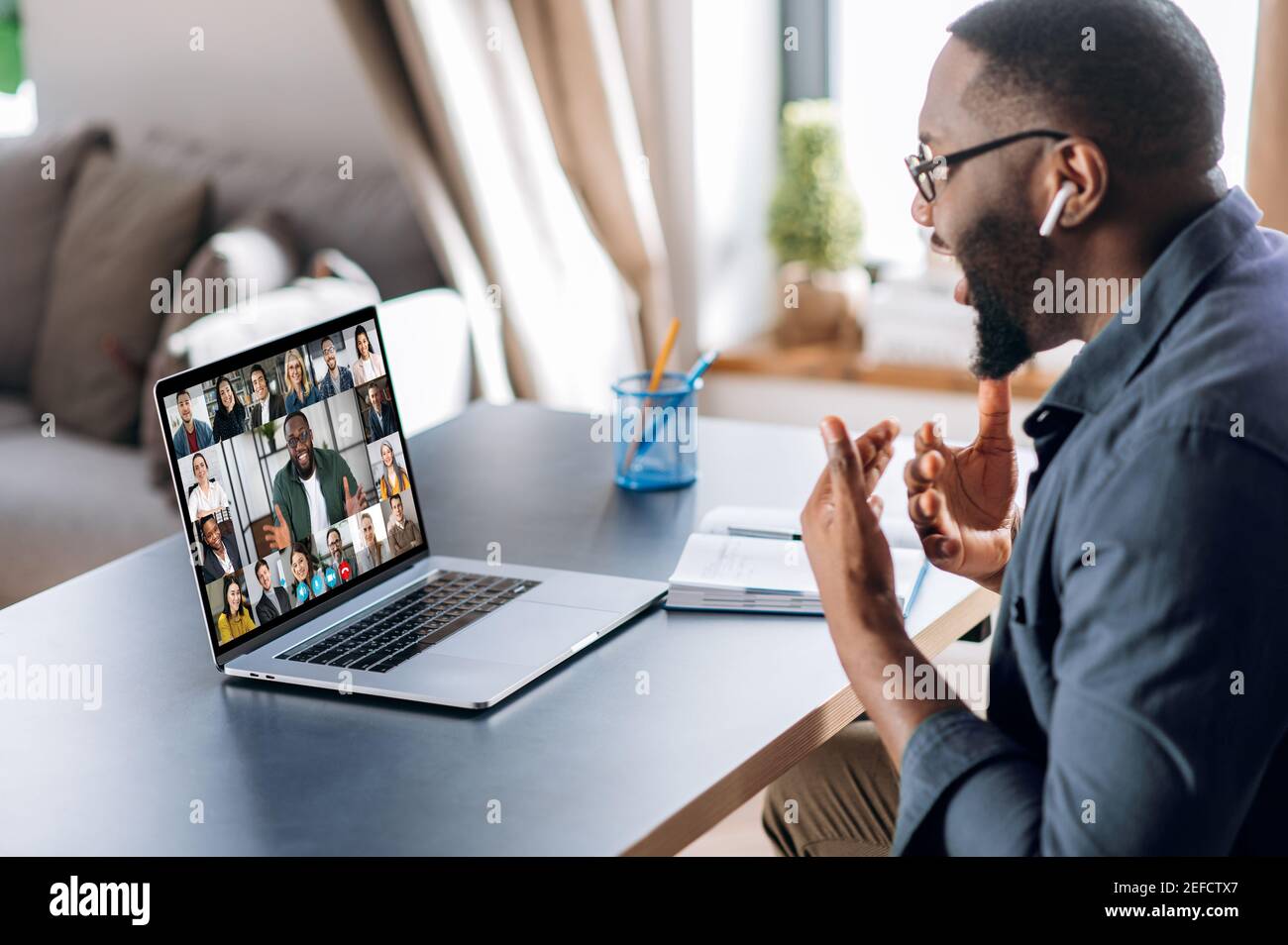 Business brainstorm, online video meeting, virtual conference with multiracial colleagues. African American man communicate with business partners by video call uses laptop and app, work from home Stock Photo