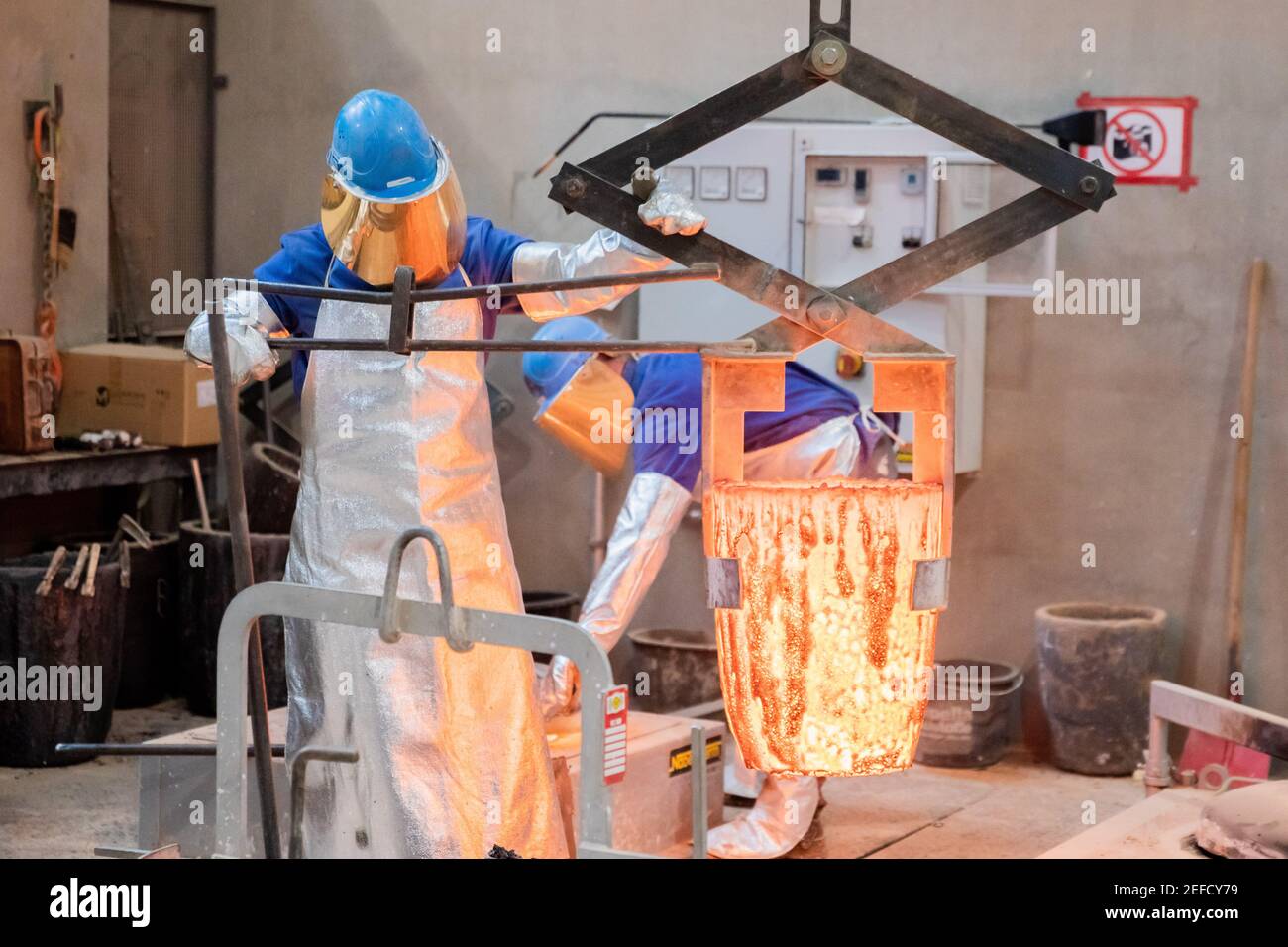 Berlin, Germany. 17th Feb, 2021. An employee of Bildgießerei Noack moves molten bronze with a crane while casting a Berlinale Bear, the trophy of the Berlin International Film Festival. This is where the Berlinale Bears are cast, manufactured and finished. The 71st Berlinale will not start in February as planned, but will be split into two dates. In March an online industry meeting is planned, in June there will be a public festival with an audience. Credit: Christoph Soeder/dpa/Alamy Live News Stock Photo