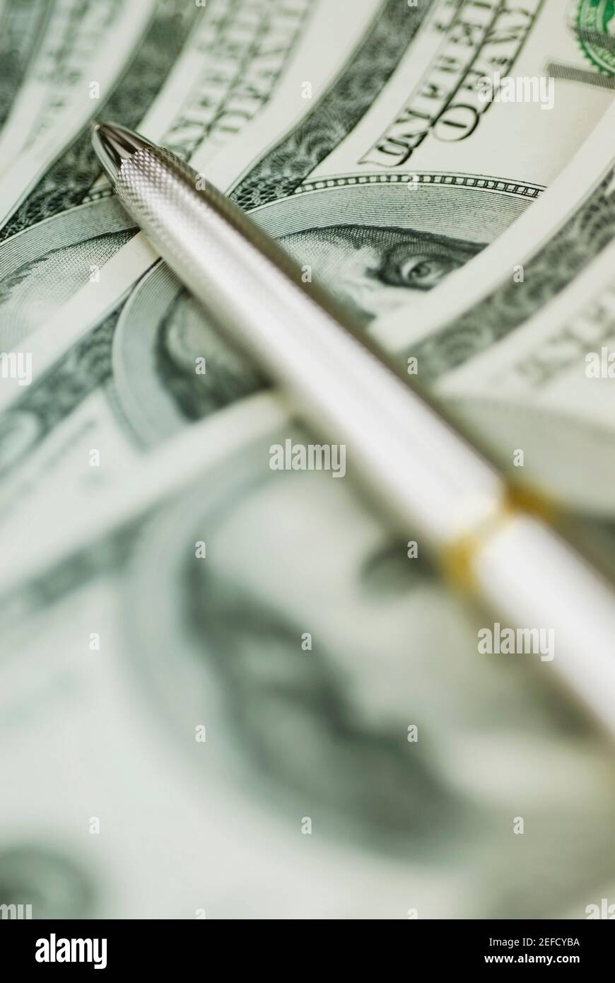 Close up of a ballpoint pen on dollar bills Stock Photo