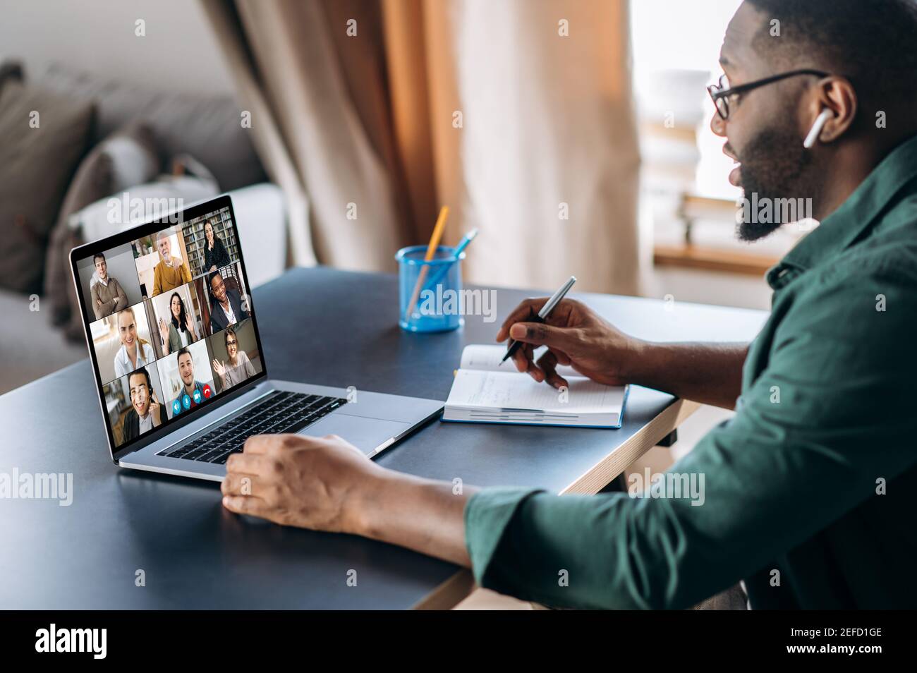 Online business briefing. Male African American employee speak on video call with diverse multiracial colleagues, on laptop screen diverse business people, meeting online, group brainstorm Stock Photo