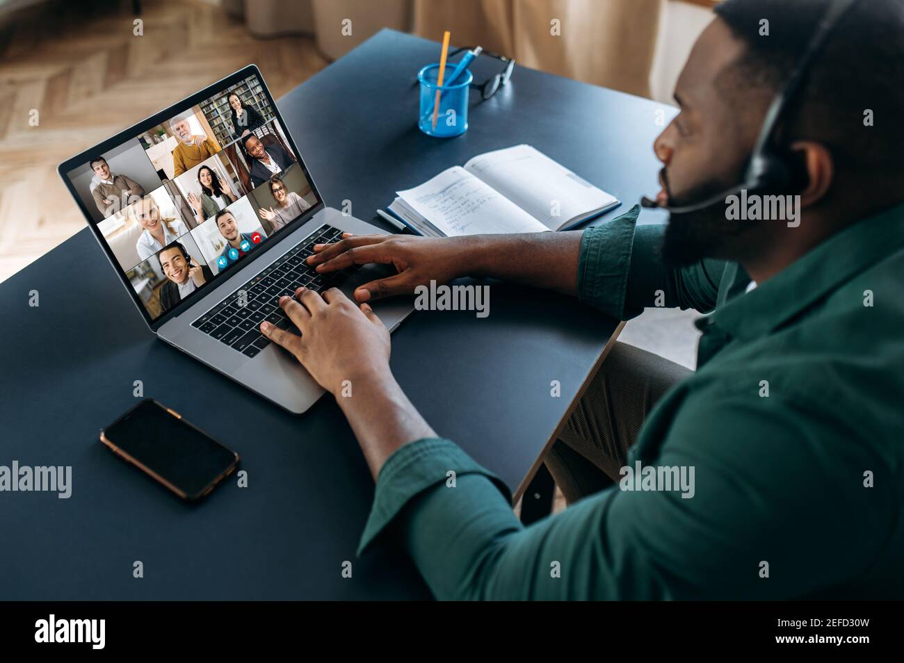 Business brainstorm, online video meeting, virtual conference with multiracial colleagues. African American man communicate with business partners by video call uses laptop and app, work from home Stock Photo