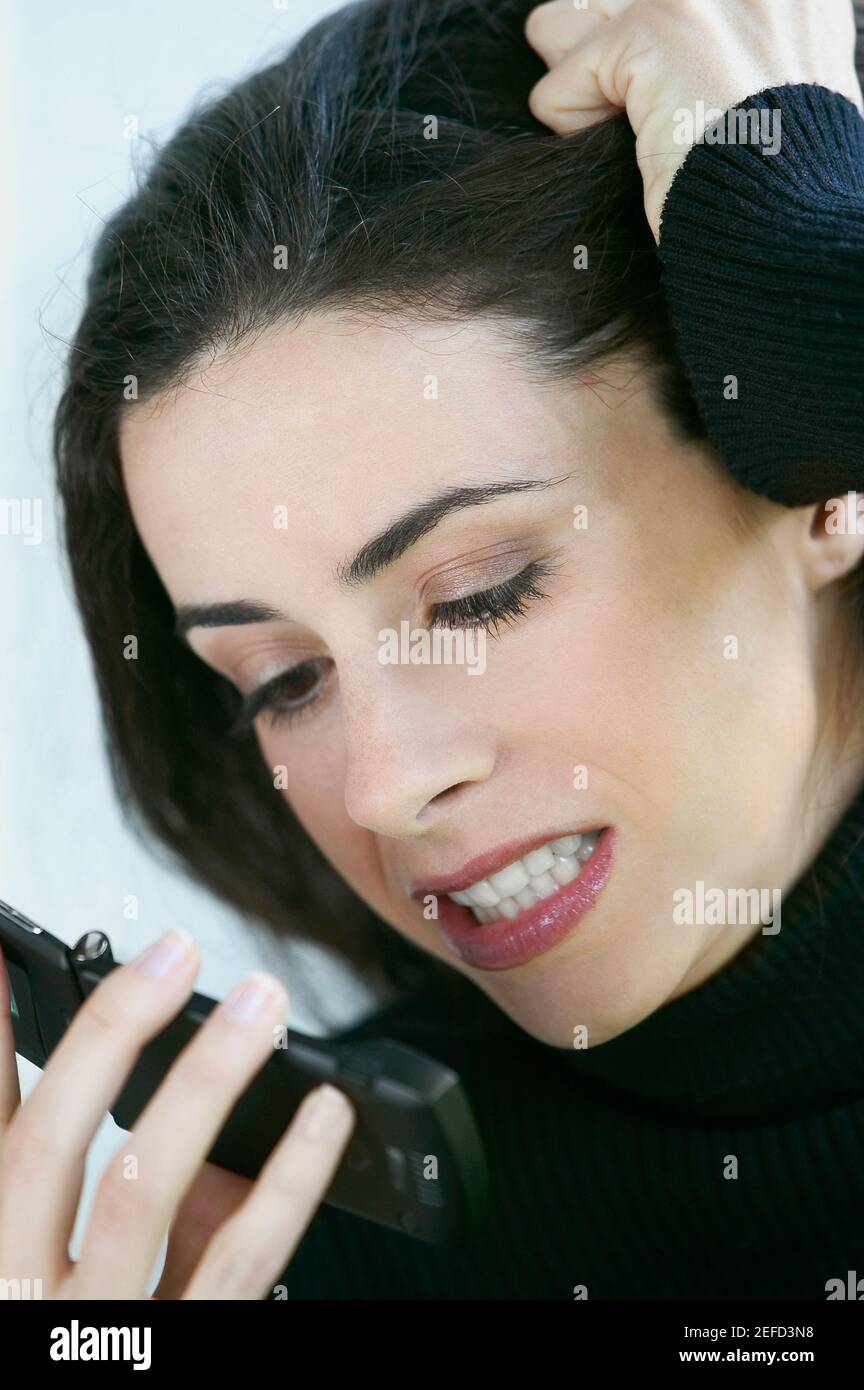 Close up of a young woman looking angry at a mobile phone Stock Photo