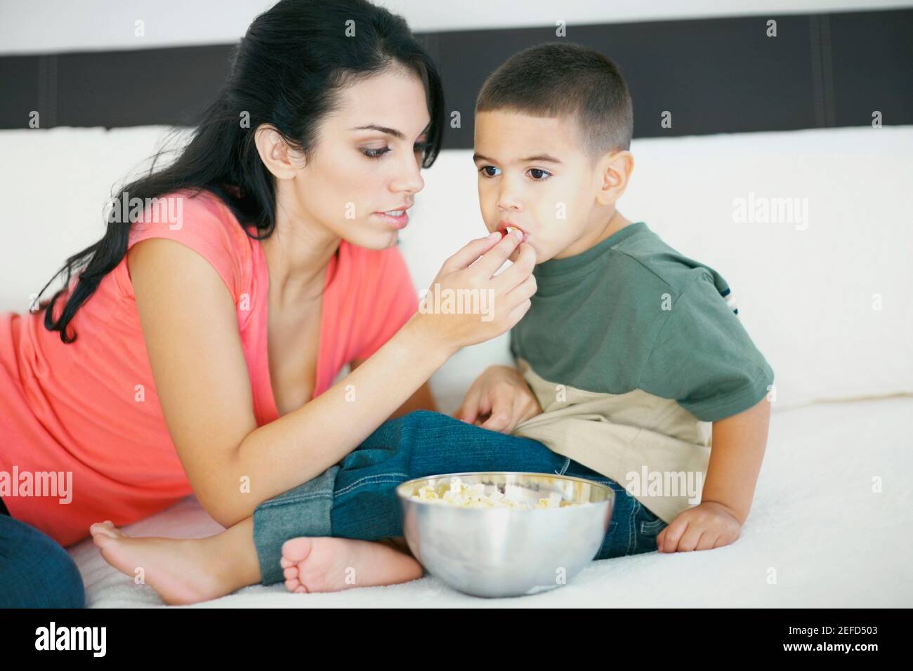 Close up of a young woman feeding her son popcorn Stock Photo