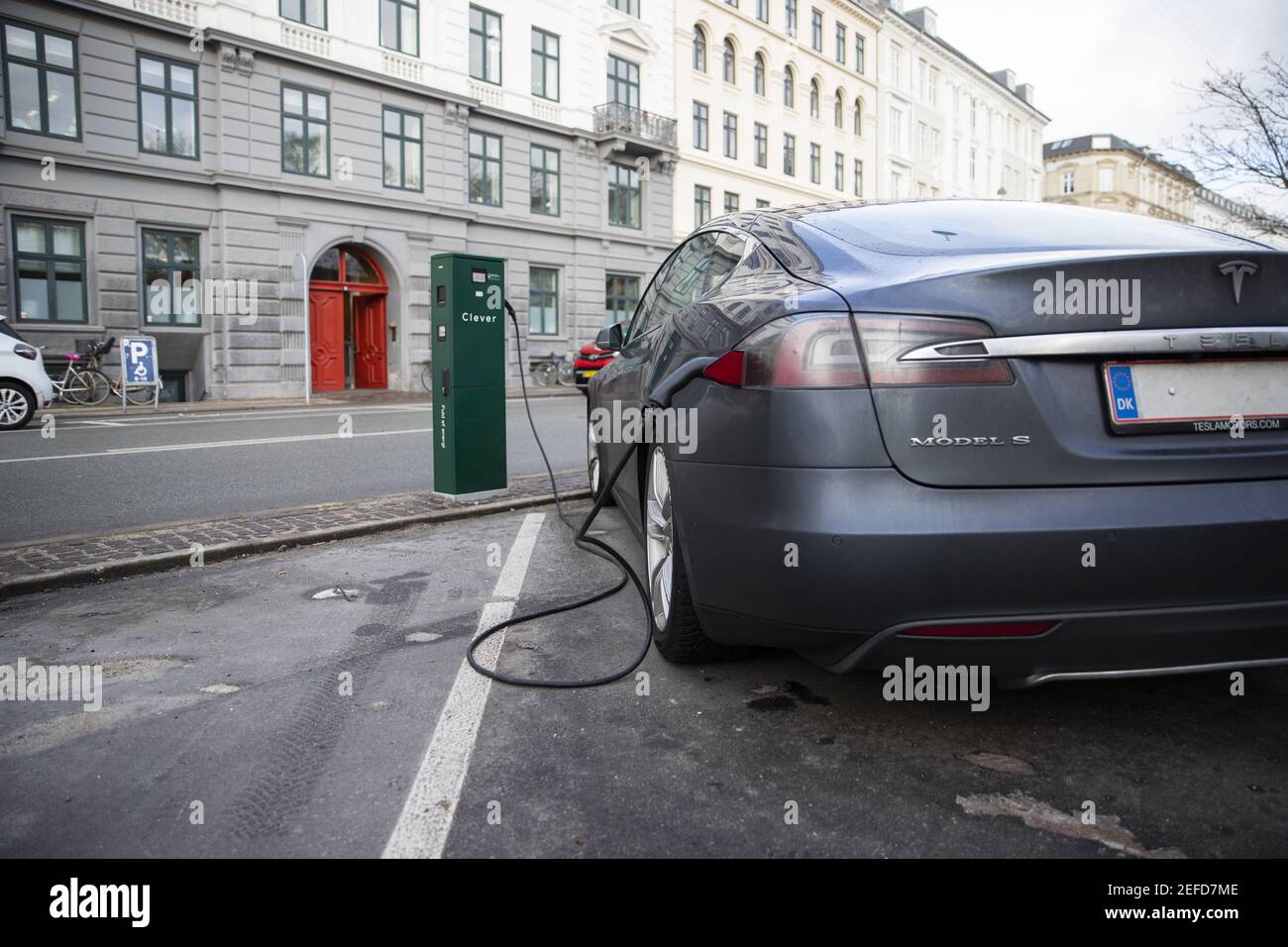 A Tesla electric car is parked and being charged. Tesla one of the