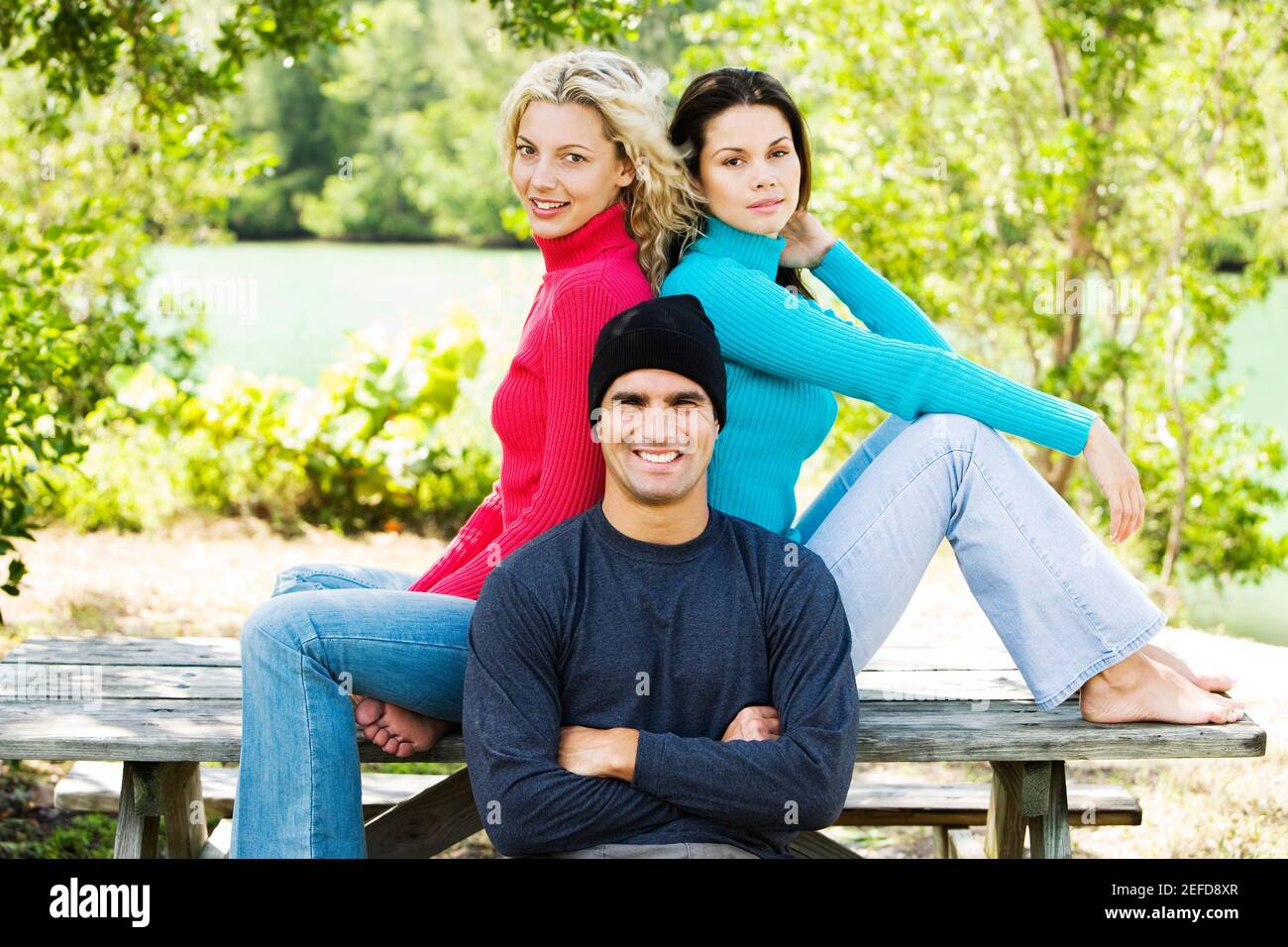 Portrait of a mid adult man and two young women smiling Stock Photo - Alamy