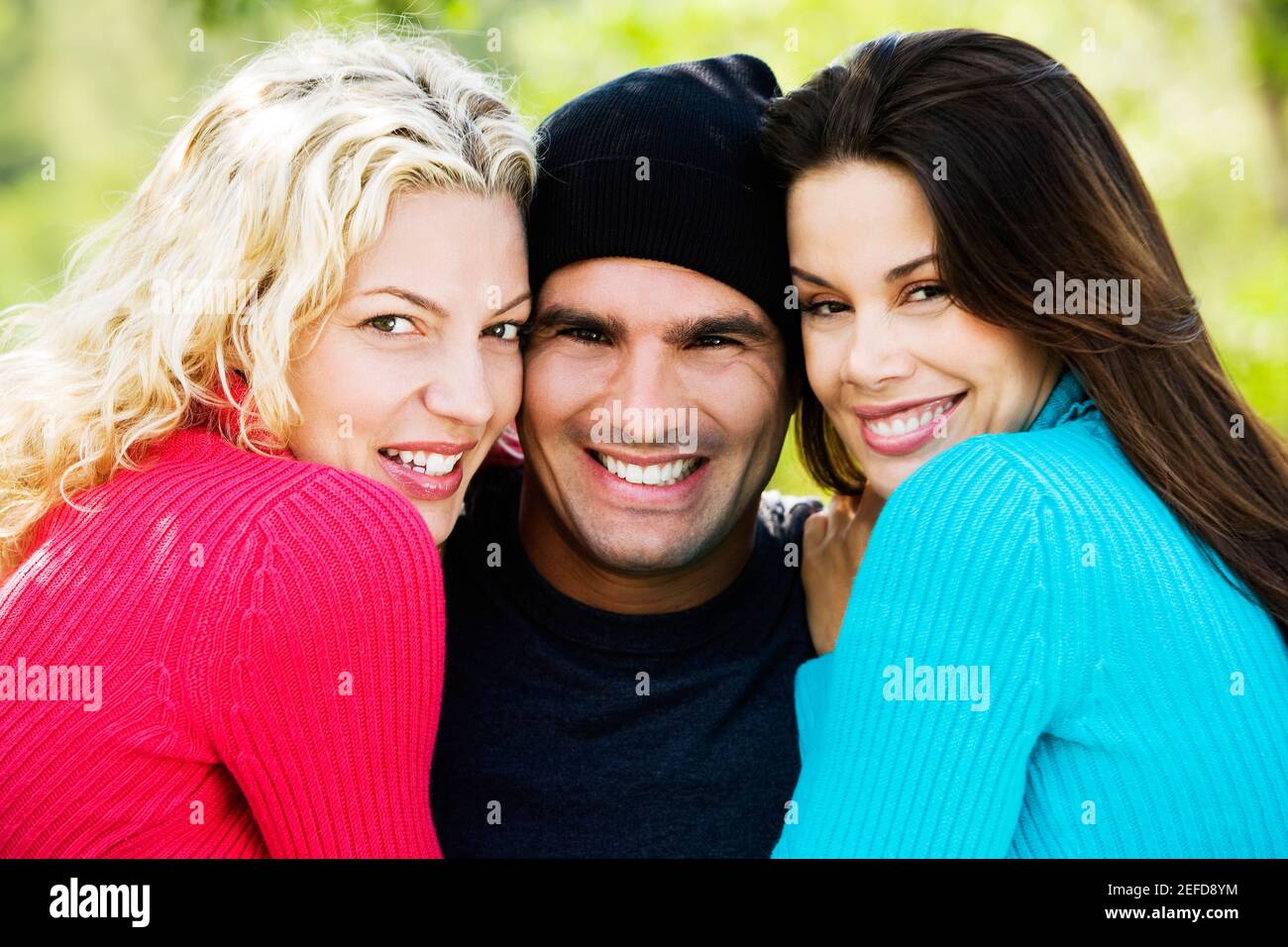 Portrait of a mid adult man and two young women smiling Stock Photo - Alamy