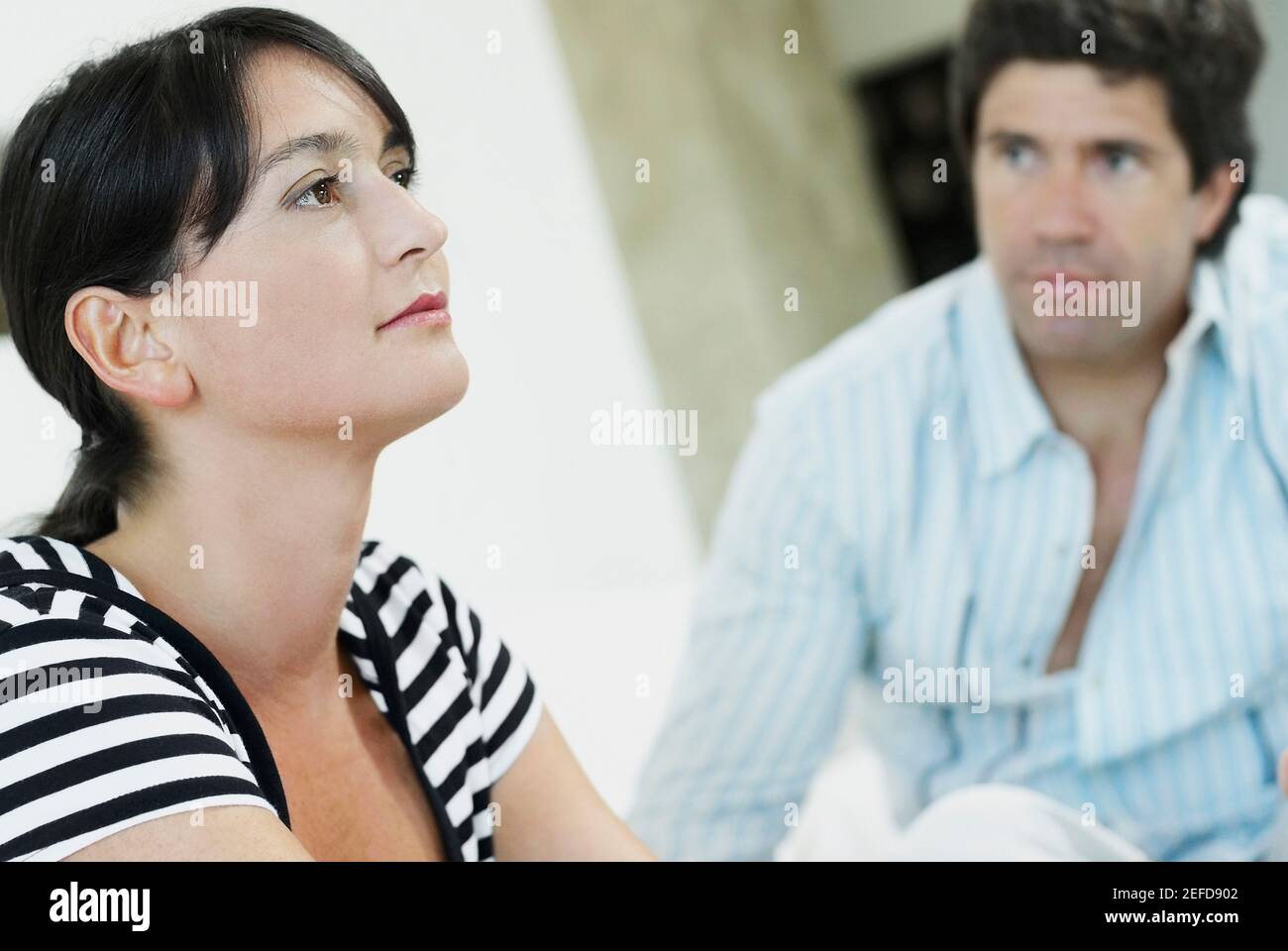 Close up of a mid adult woman with a mid adult man looking at her Stock ...