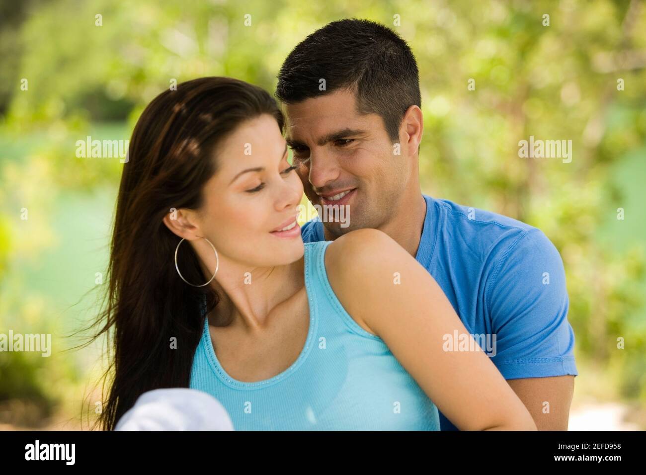 Close-up of a mid adult man embracing a young woman from behind Stock ...