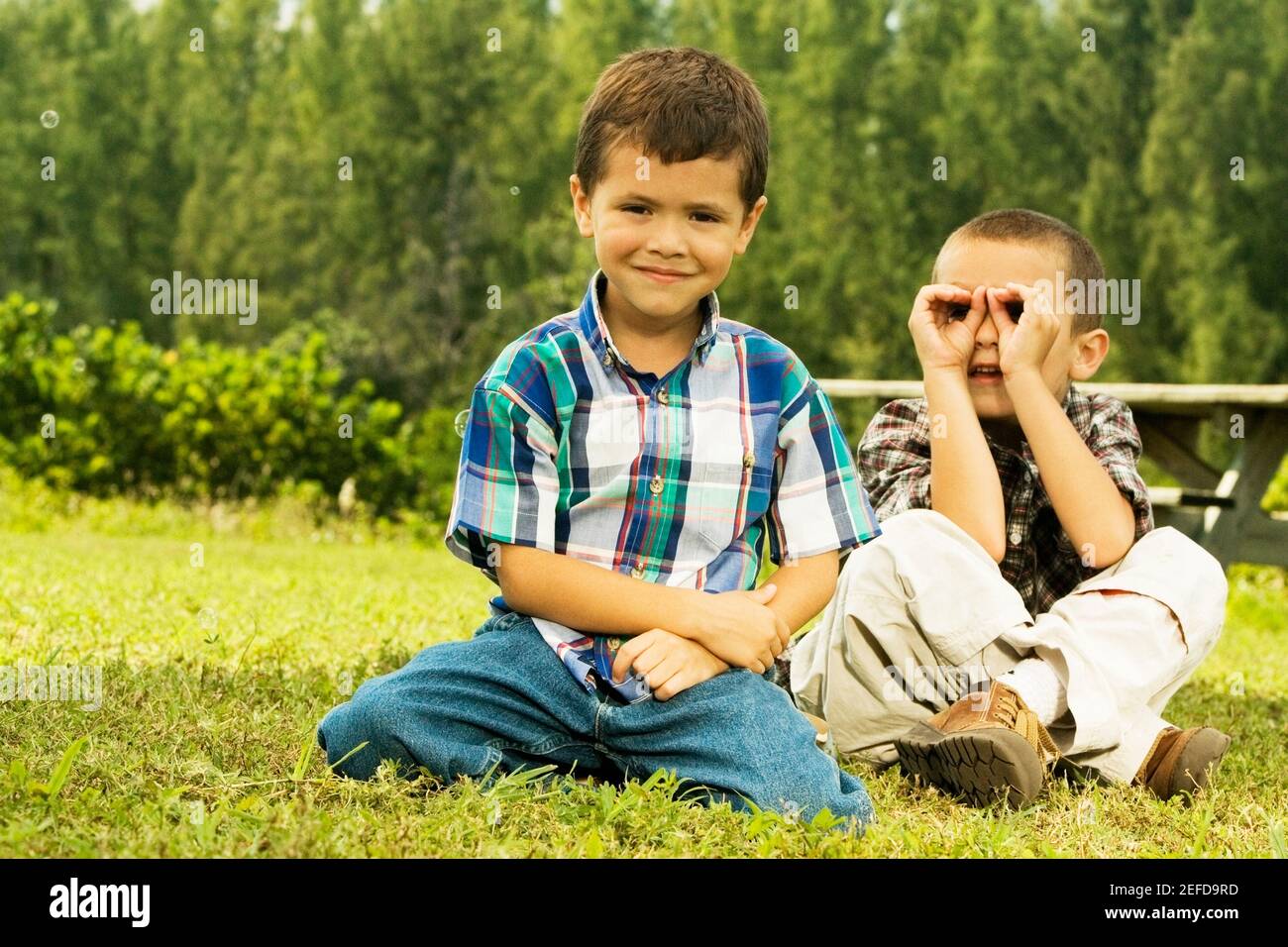 Portrait of two boys sitting on the lawn Stock Photo - Alamy