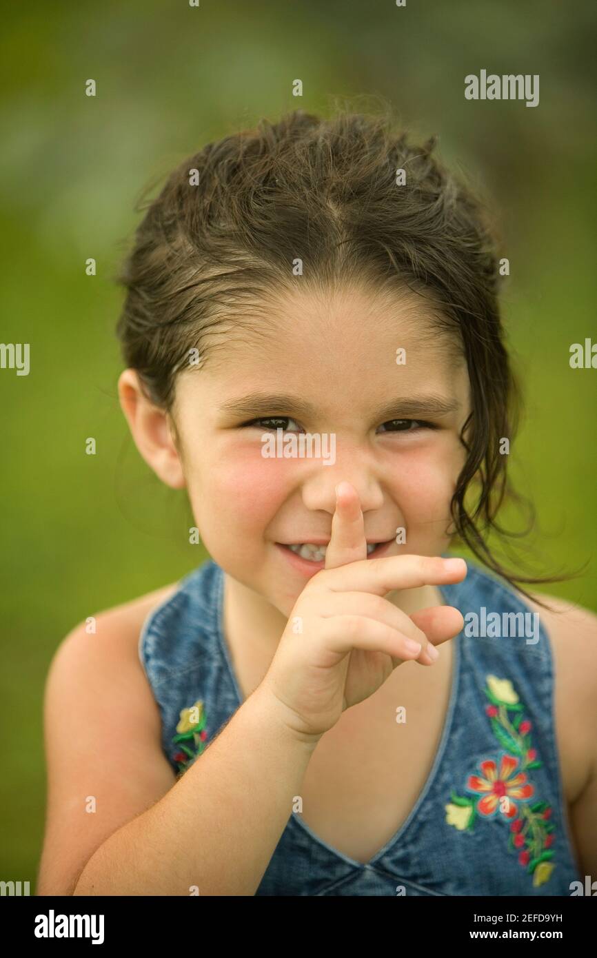 Portrait of a girl with her finger on her lips Stock Photo - Alamy