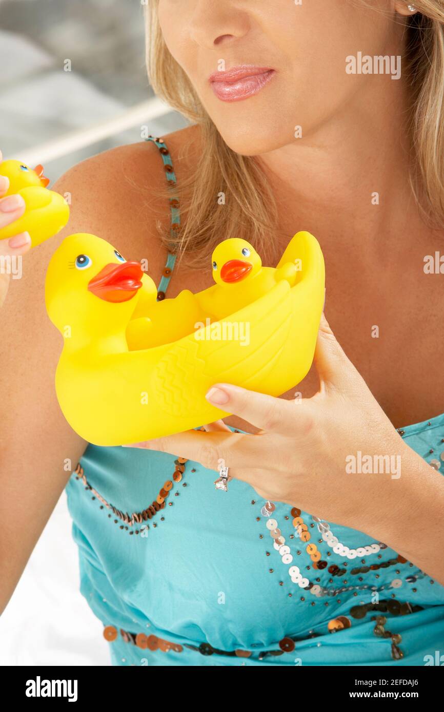Close-up of a mid adult woman holding rubber ducks Stock Photo
