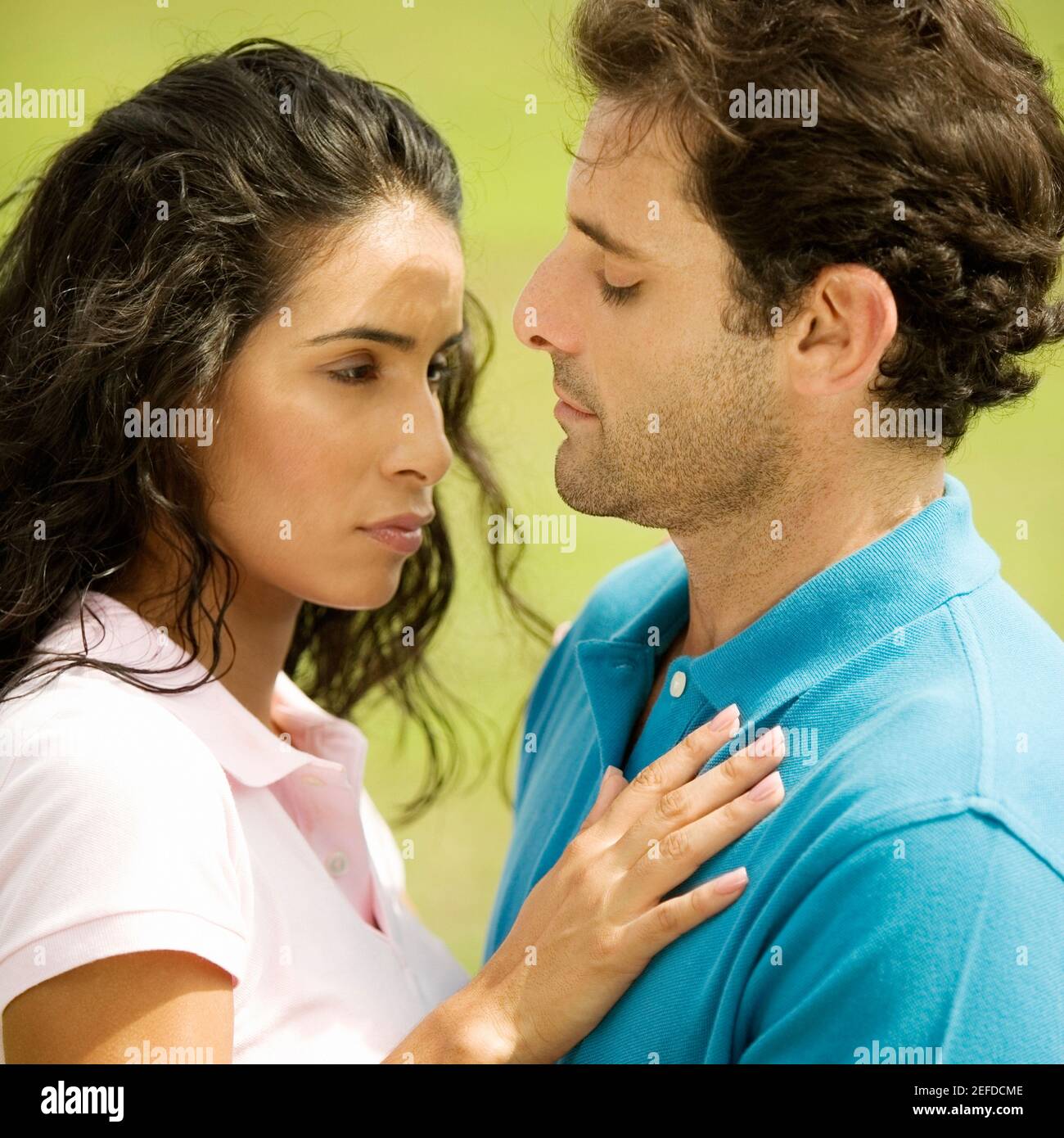 Side profile of a mid adult man embracing a young woman Stock Photo - Alamy