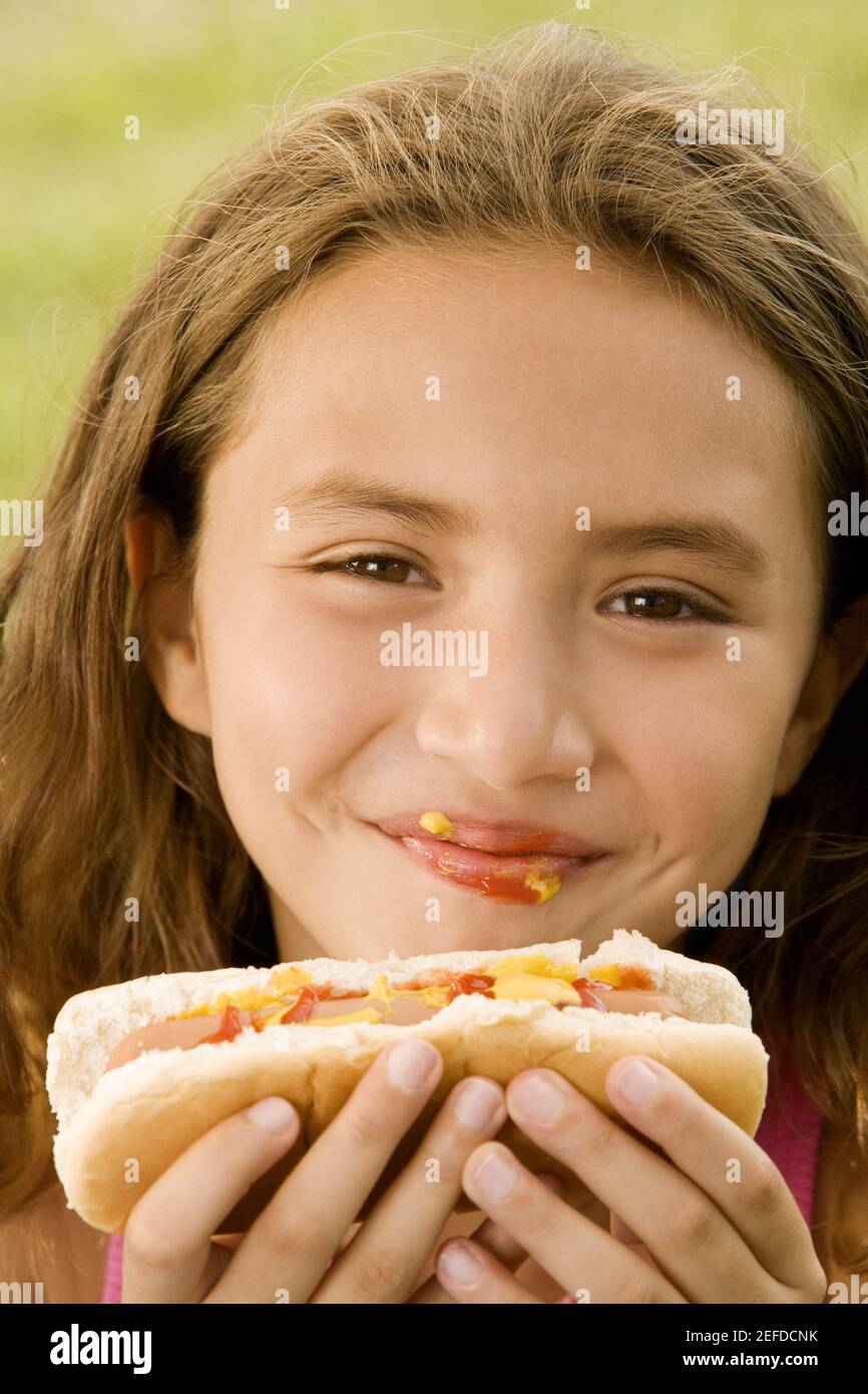 Portrait of a girl eating a hotdog Stock Photo