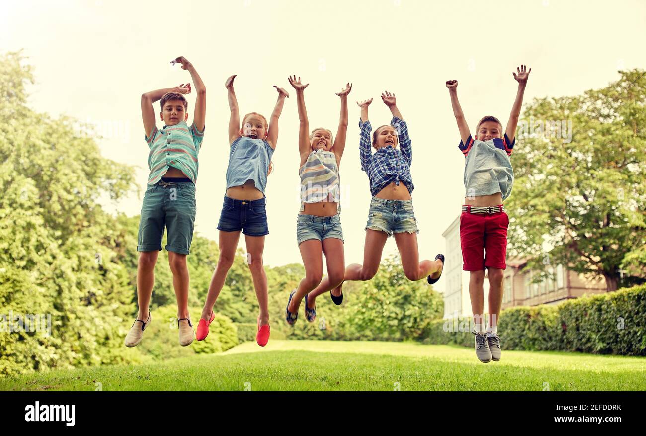 happy kids jumping and having fun in summer park Stock Photo