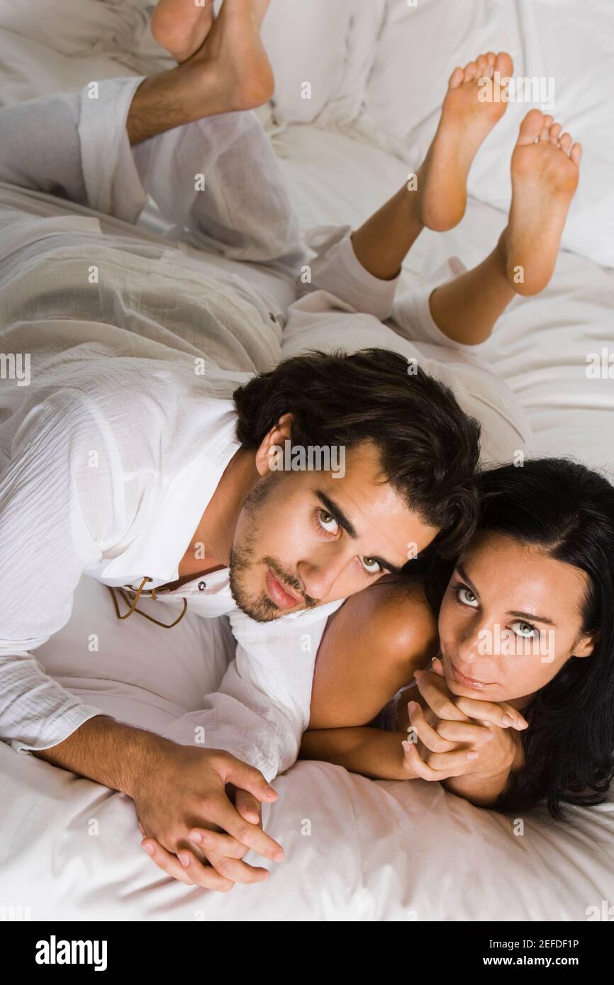 High angle view of a young couple lying down on a bed Stock Photo - Alamy