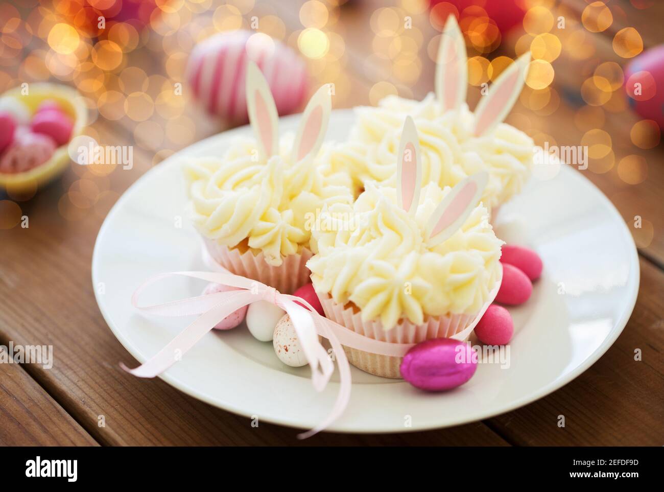 cupcakes with easter eggs and candies on table Stock Photo