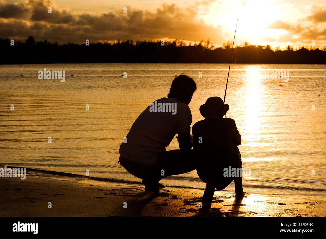Father son silhouette fishing sunset hi-res stock photography and ...