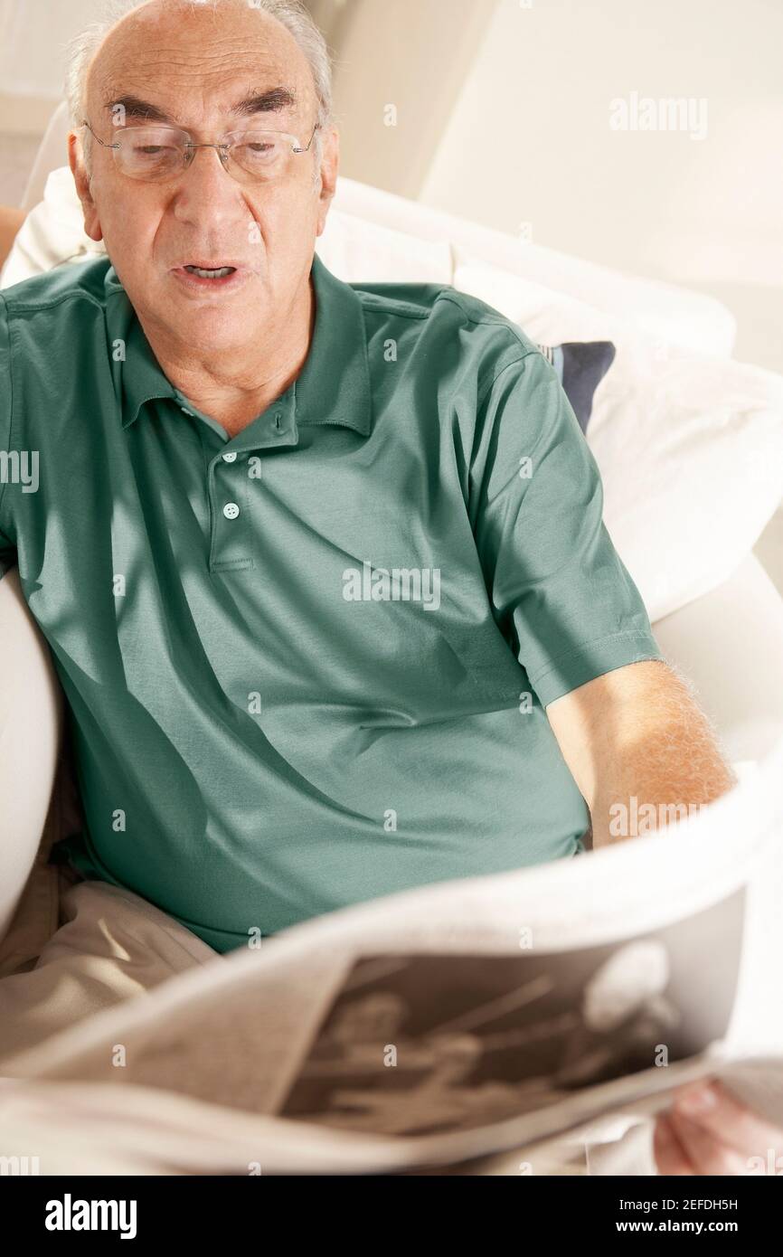 High angle view of a senior man reading a newspaper Stock Photo