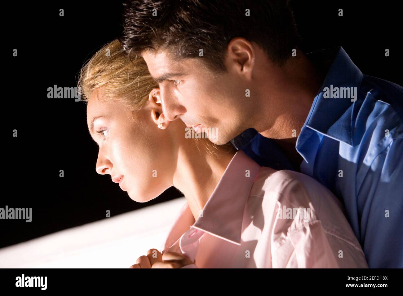 Side profile of a mid adult man embracing a young woman Stock Photo - Alamy