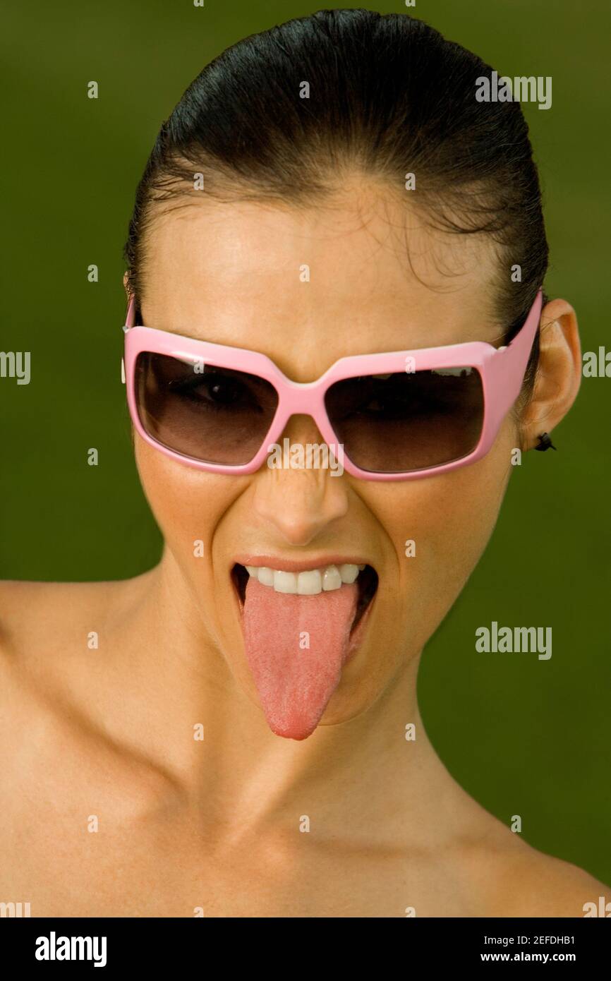 Close-up of a mid adult woman sticking out her tongue Stock Photo