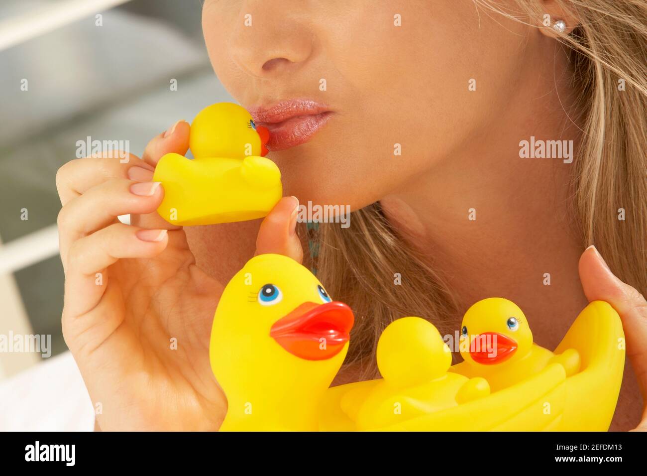 Close-up of a mid adult woman kissing a rubber duck Stock Photo