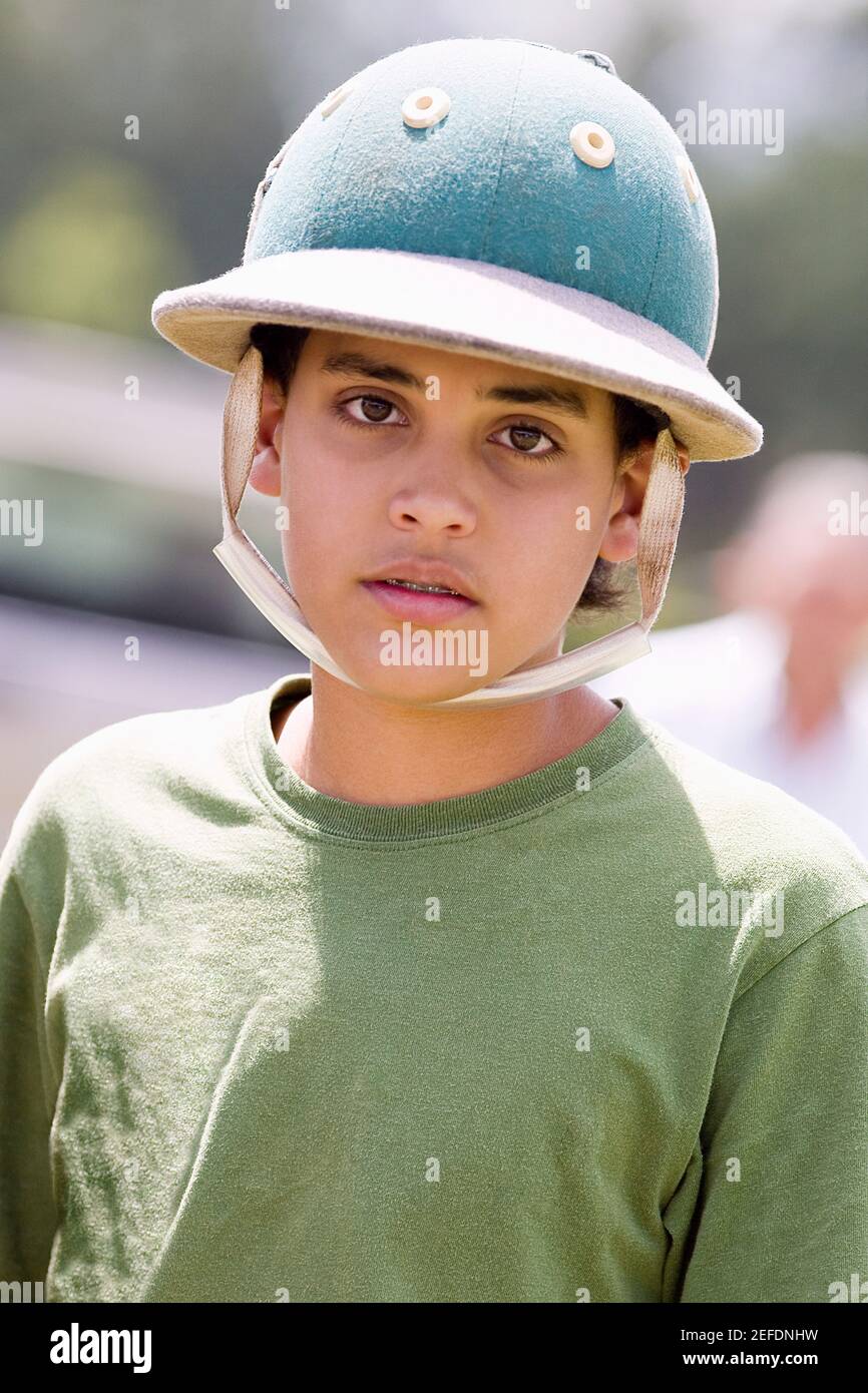Portrait of a teenage boy wearing a polo helmet Stock Photo - Alamy
