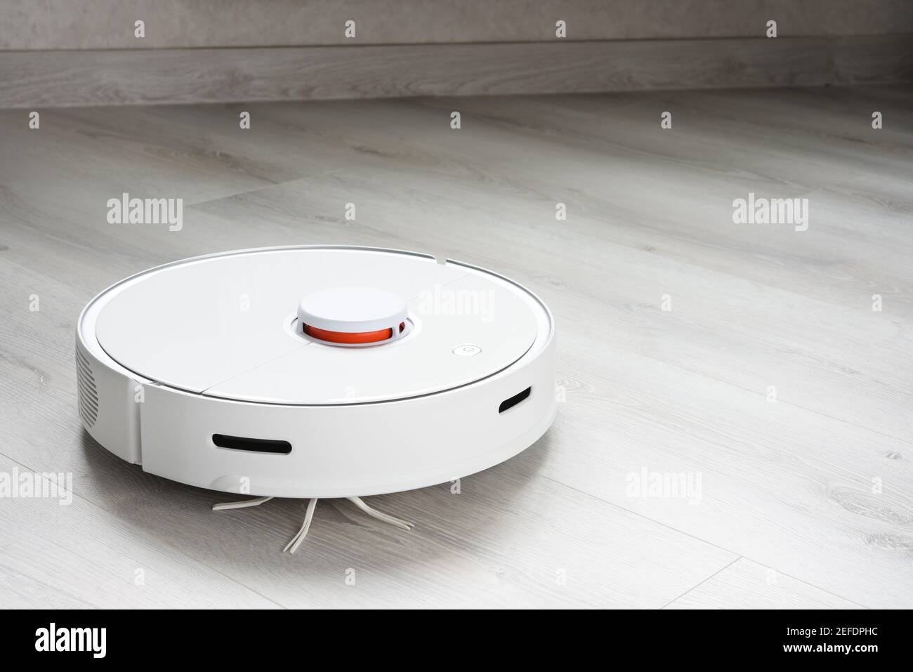 A robot vacuum cleaner helps in cleaning an apartment or house Stock