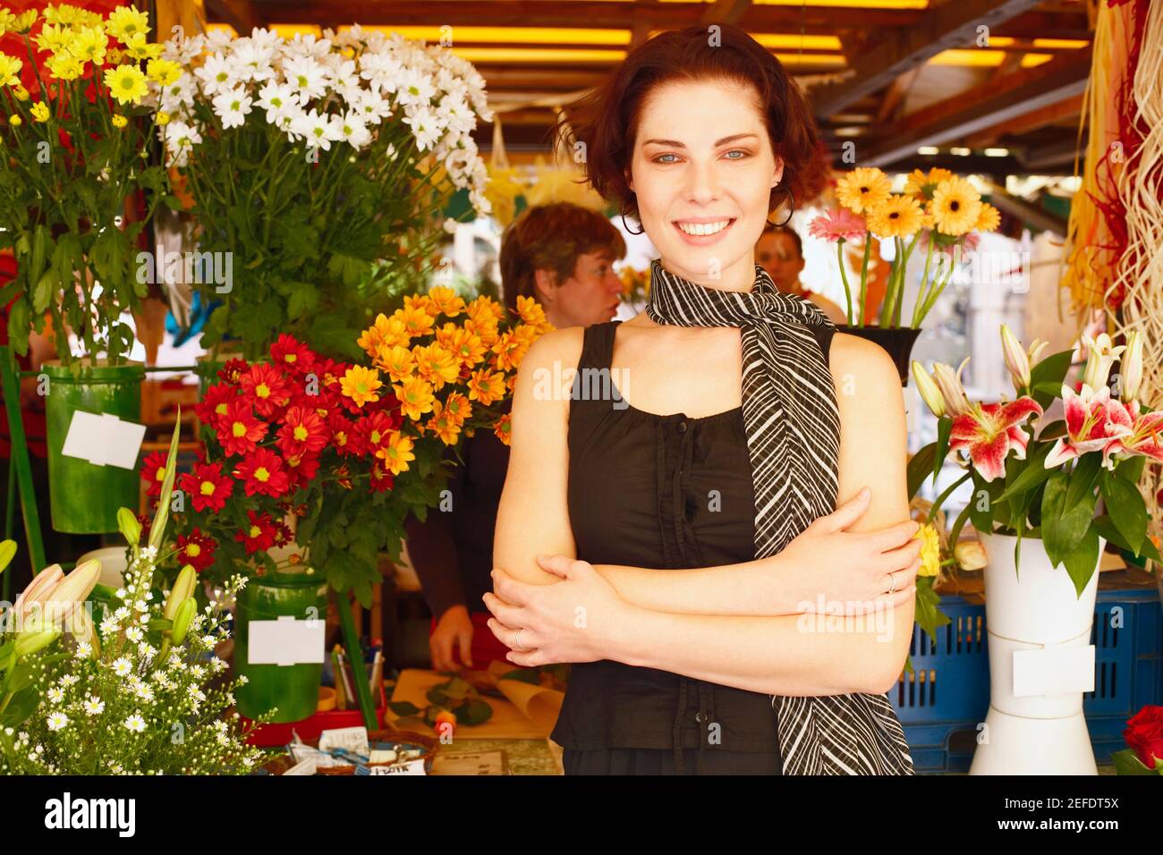 Portrait of a young woman standing in a flower market Stock Photo - Alamy