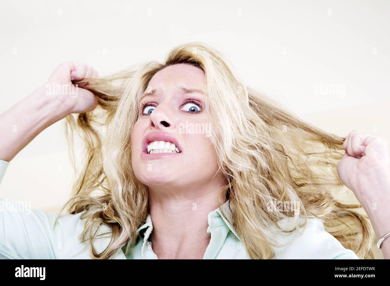 Portrait of a young woman pulling her hair and clenching her teeth Stock  Photo - Alamy