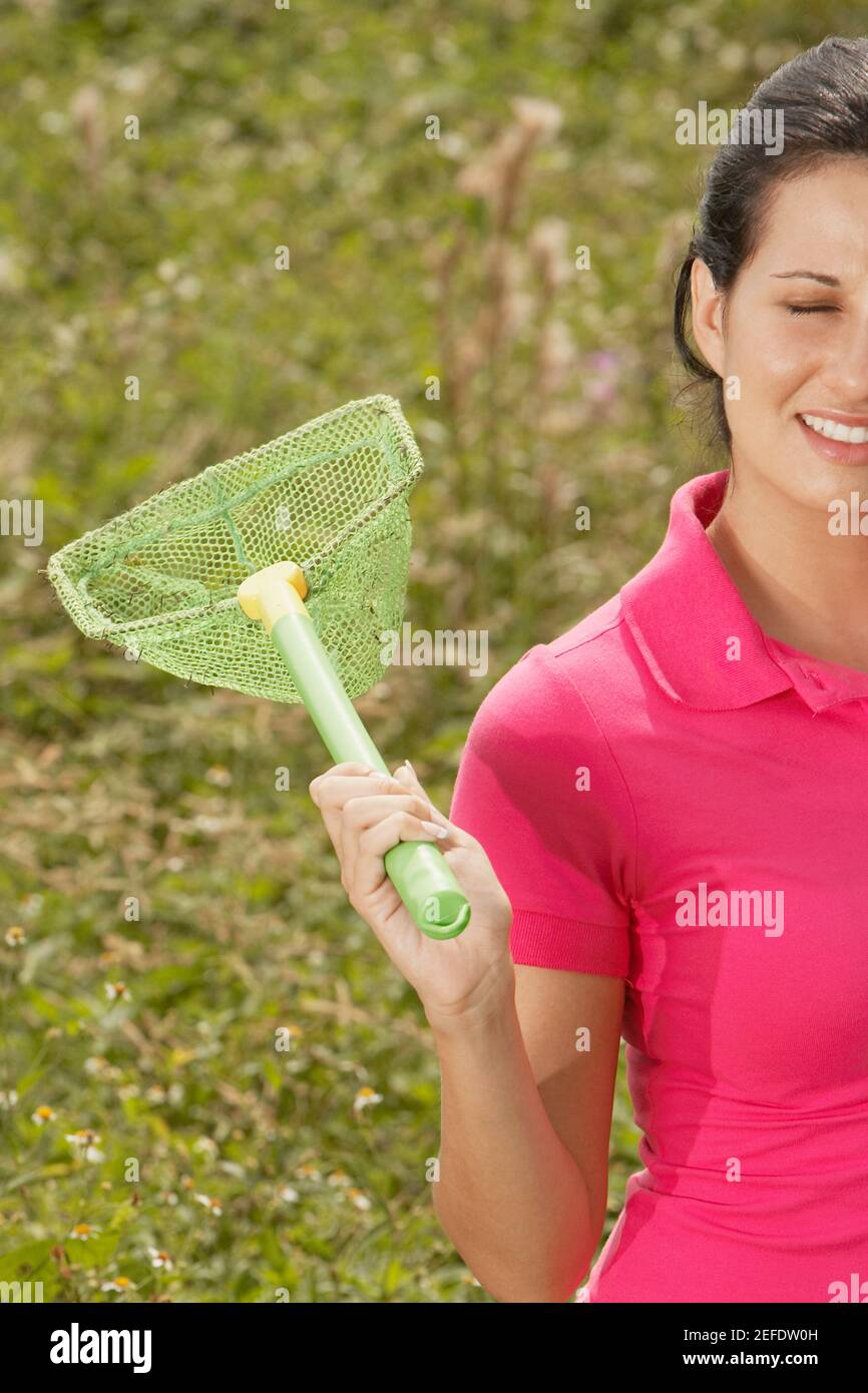 Close-up of a young woman holding a butterfly net Stock Photo - Alamy