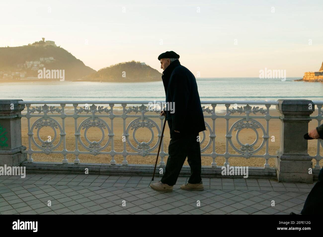 Side profile of a senior man walking on the seaside, Spain Stock Photo