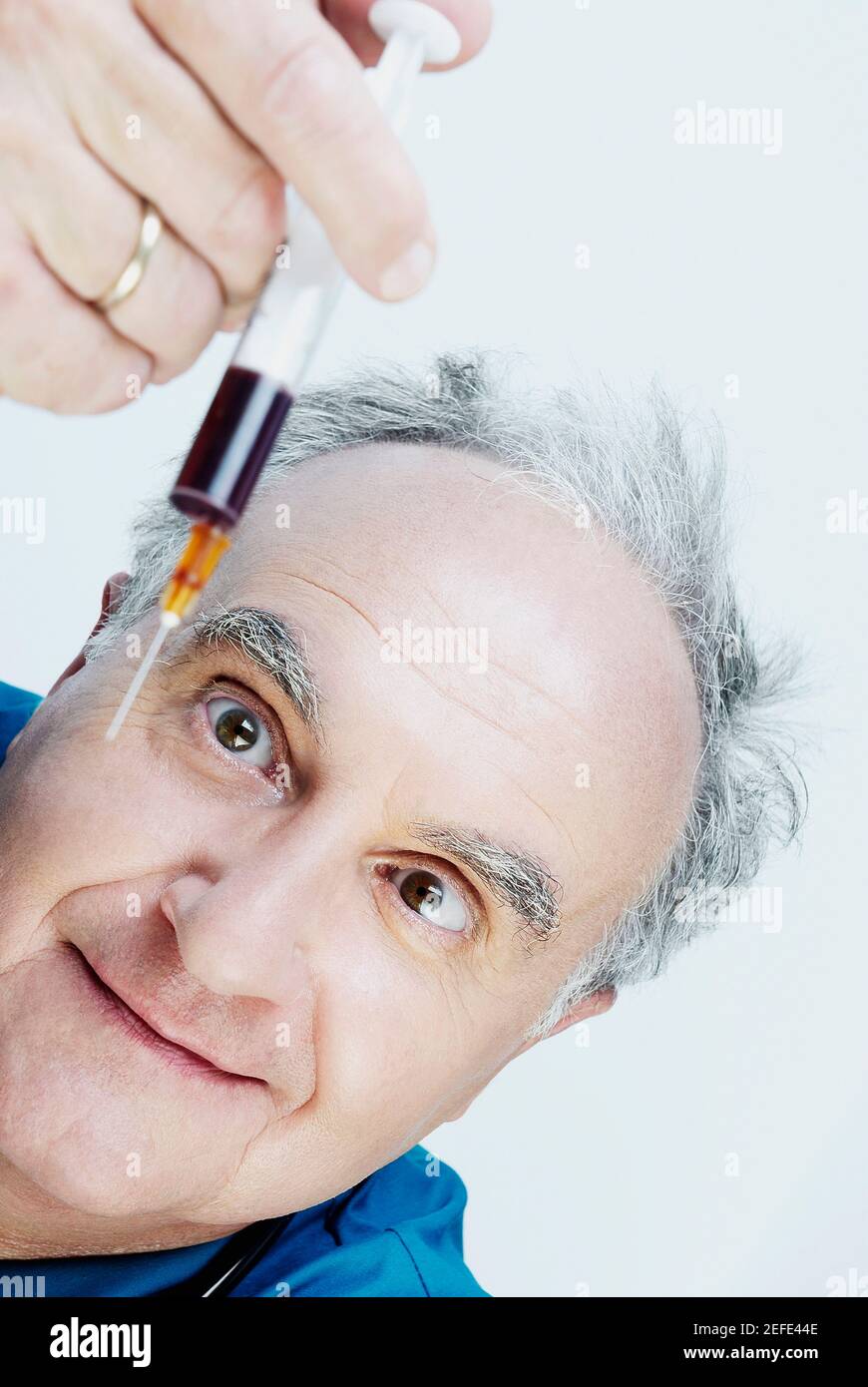 Close up of a male doctor holding a syringe Stock Photo