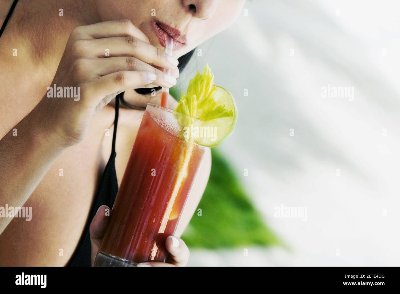 Close-up of a young woman drinking a bloody mary Stock Photo